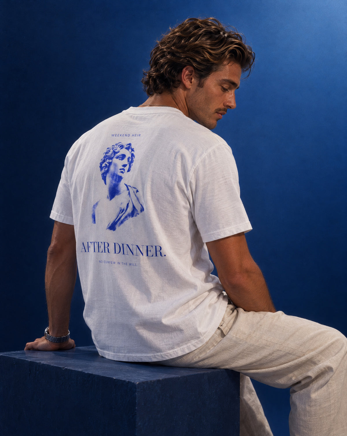 White | Lifestyle | WEEKEND HEIR After Dinner Tee in White, studio portrait on cobalt, marble bust engraving on the back