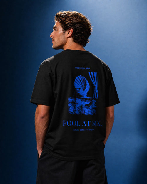 Black | Lifestyle | WEEKEND HEIR Pool at Six Tee in Black, studio portrait on cobalt, shell fountain engraving on the back