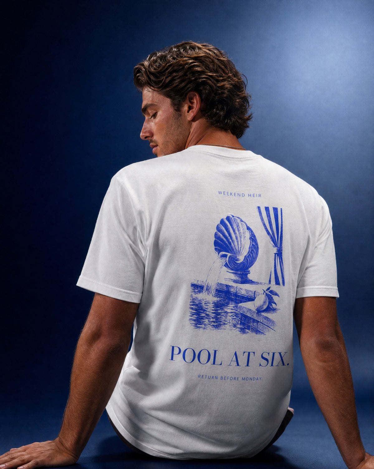 White | Lifestyle | WEEKEND HEIR Pool at Six Tee in White, studio portrait on cobalt, shell fountain engraving on the back