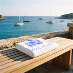 Scene | Pool at Six Beach Towel folded on a bench above the sea